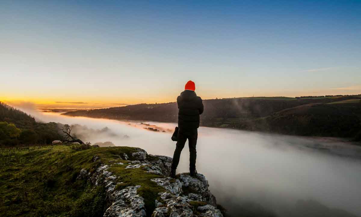 A walker looks at Inverted clouds over Wrexham and Denbighshire at sunrise